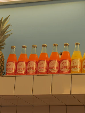 Close-up of colorful cold-pressed juice bottles lined up on a wooden table