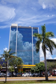a tall building with a sky reflection on the side of it