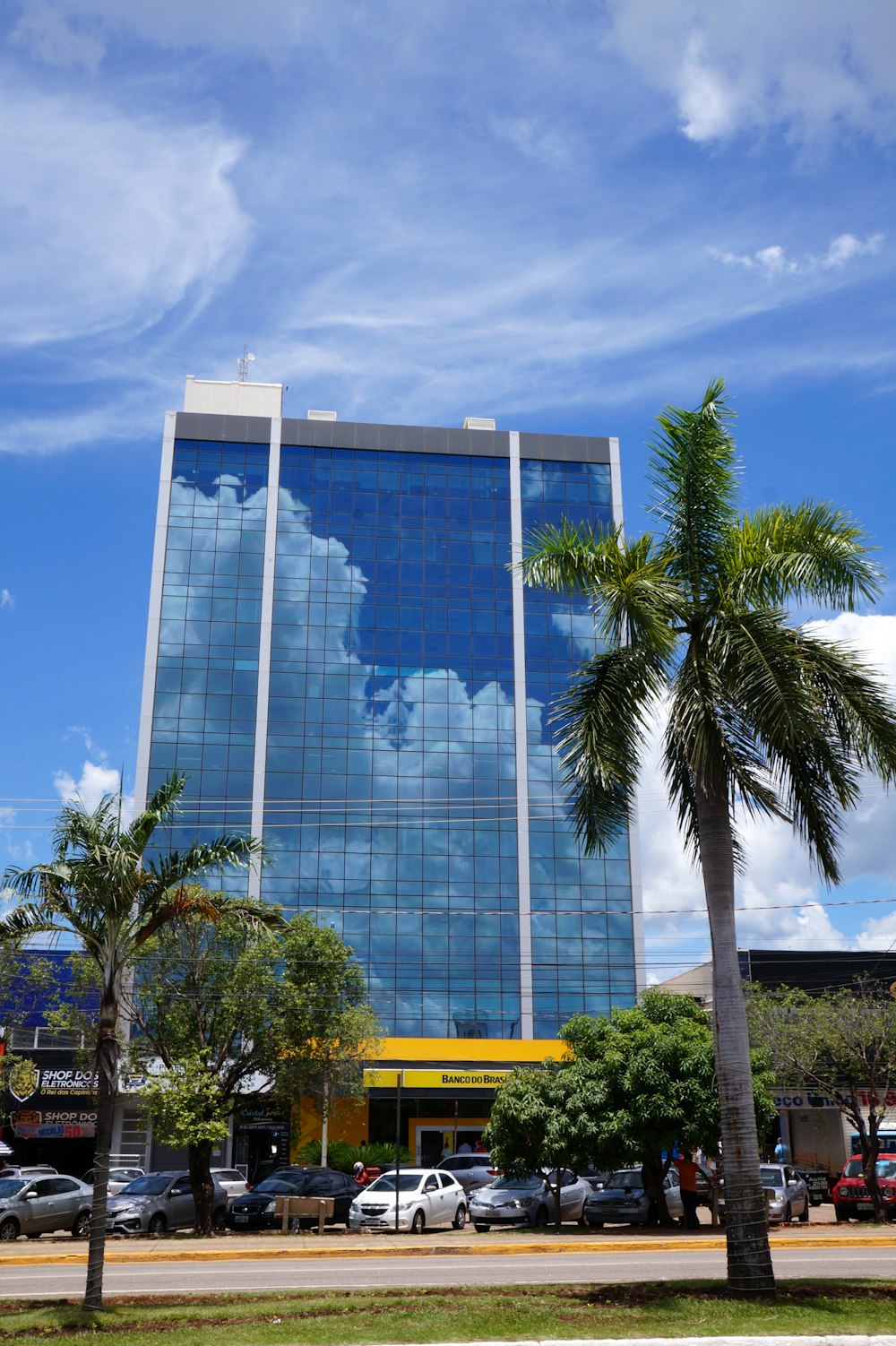 a tall building with a sky reflection on the side of it