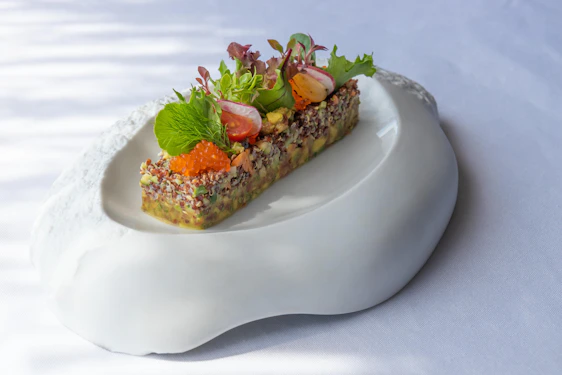 A beautifully arranged platter showcasing colorful, fresh ingredients and artfully plated dishes in a bright, modern setting.
