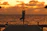 A peaceful morning yoga session taking place on a wooden deck overlooking the serene ocean at sunrise.