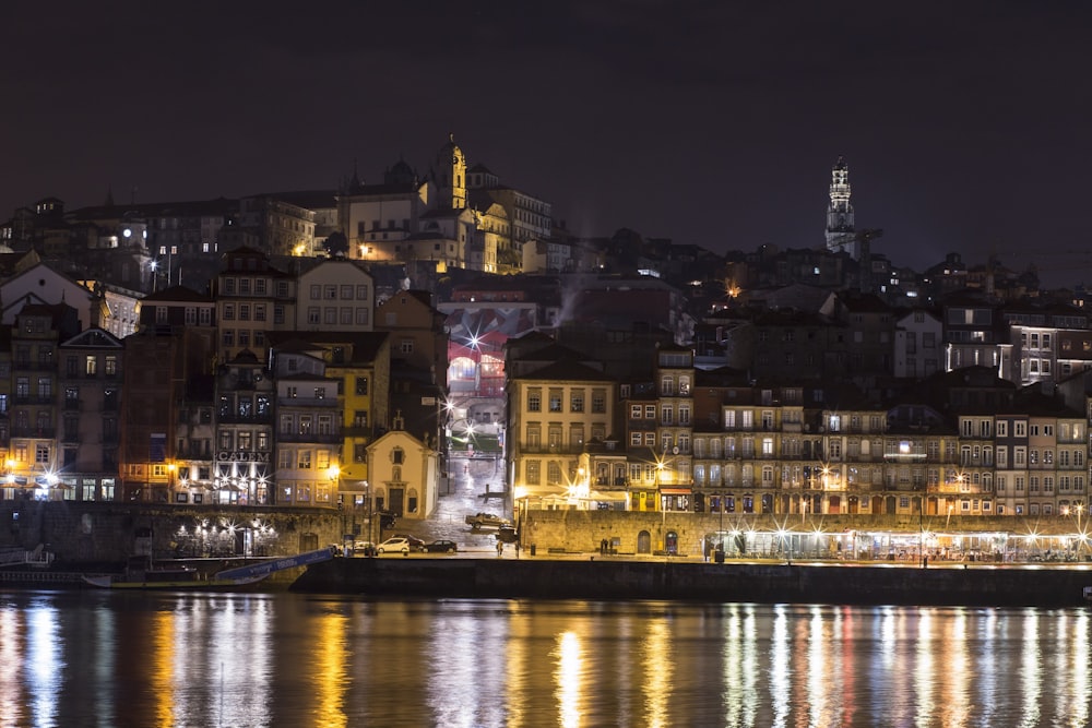 a city at night with lights reflecting in the water