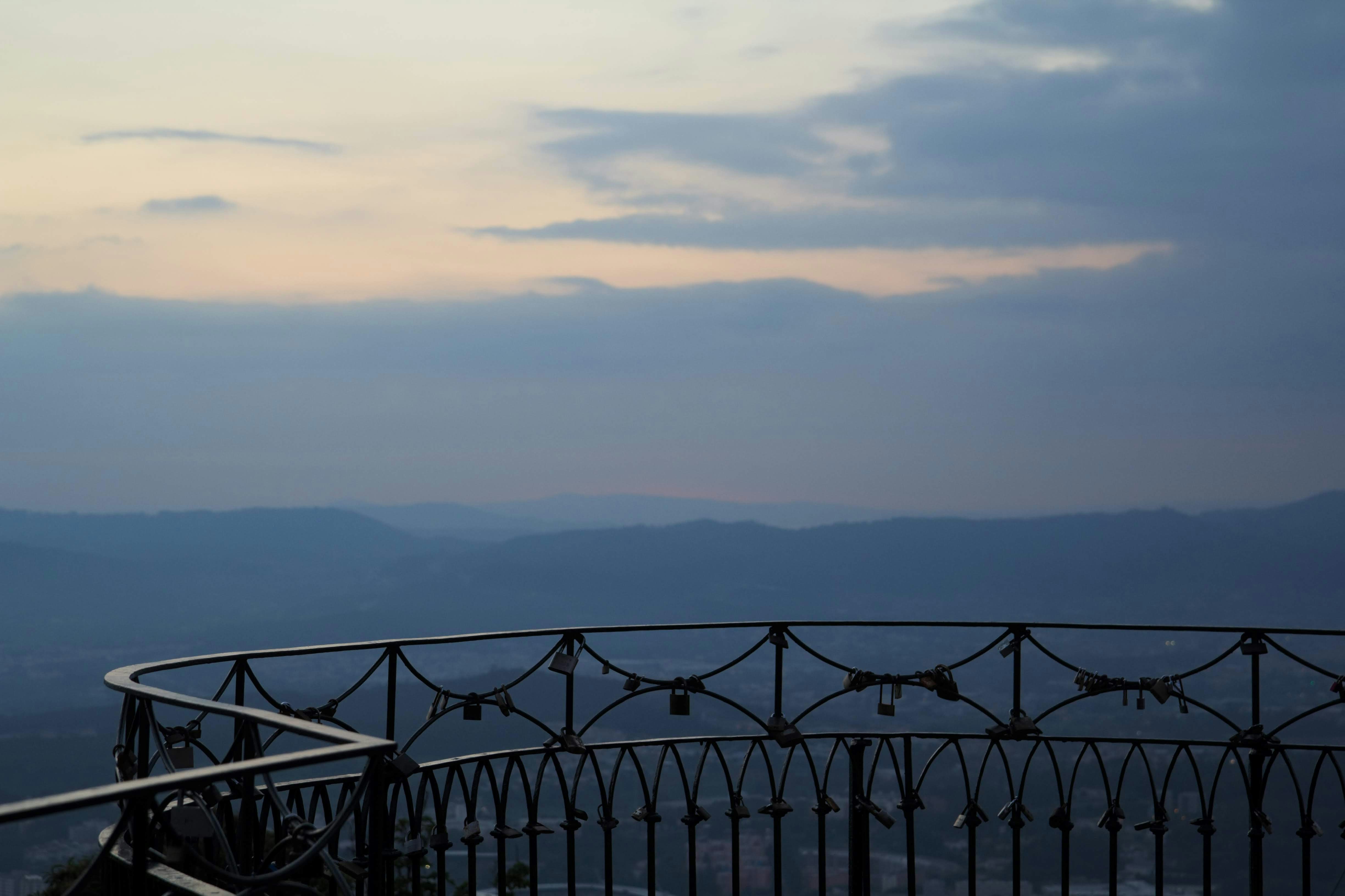 A metal railing with a view of mountains in the distance photo – Free ...