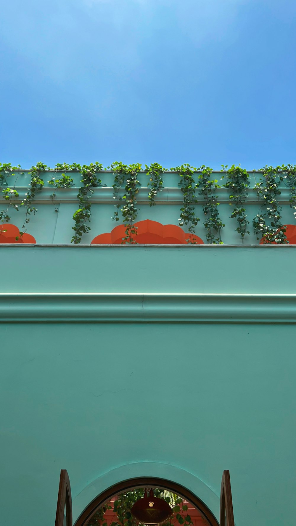 a green building with plants growing on the roof