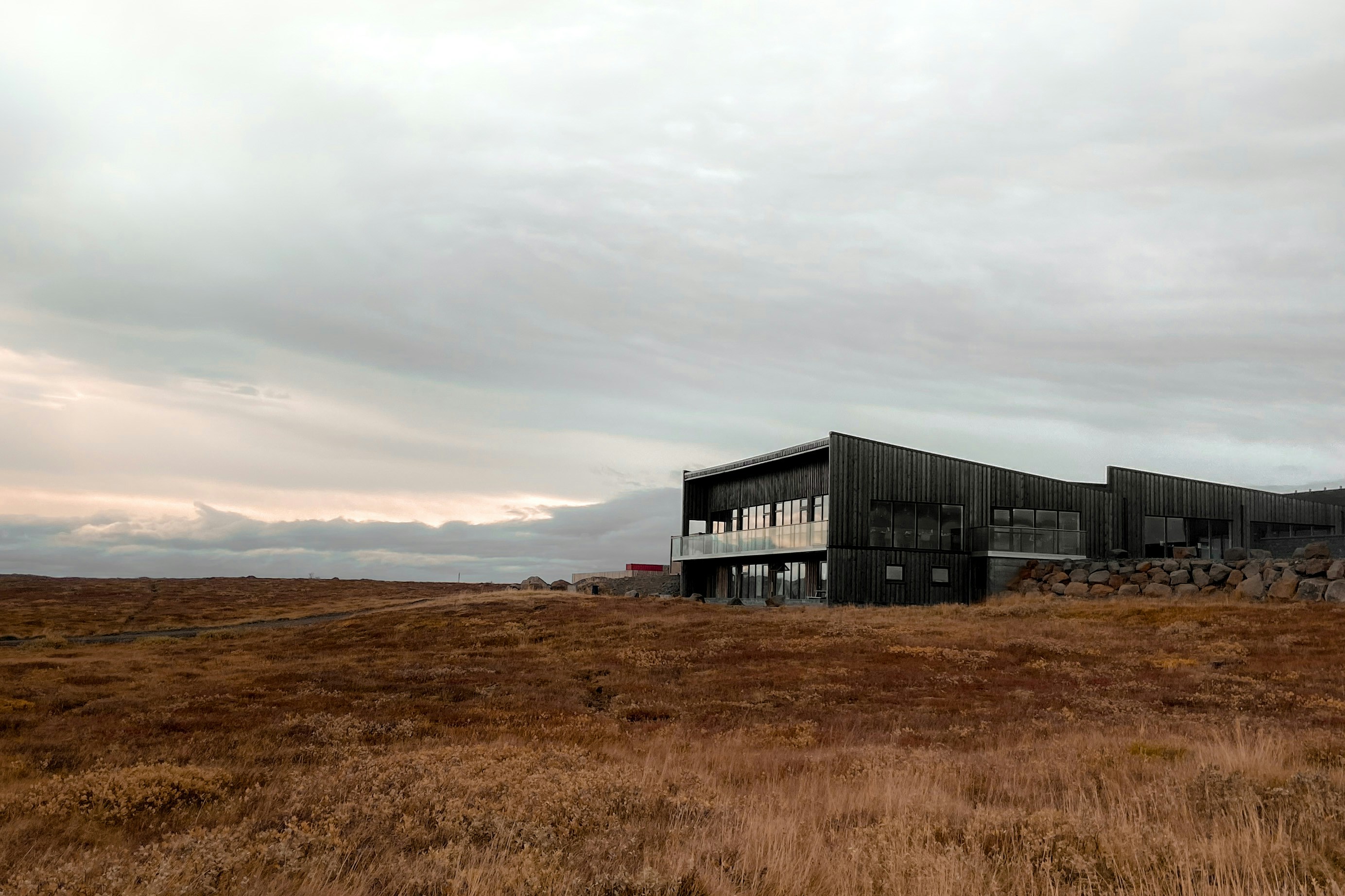a large building sitting on top of a dry grass field