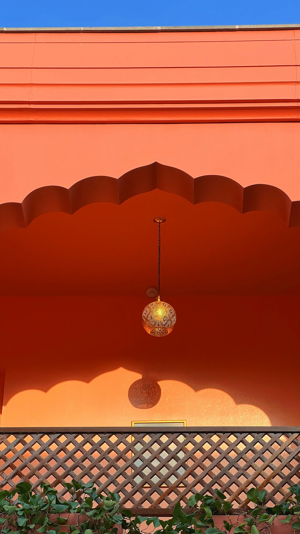 ein orangefarbenes Gebäude, an dessen Seite ein Licht hängt