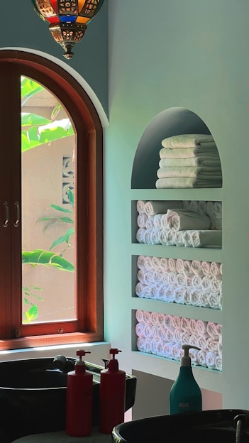 A stylish display of striped bath towels and a green area rug.