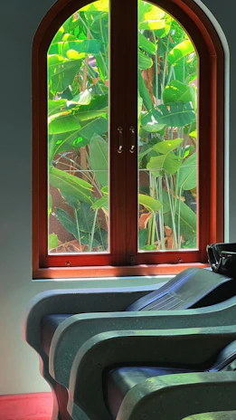 A peaceful scene of a quiet room with soft sage green walls and a comfortable chair by a window.