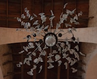 An elegant vintage chandelier hanging over a rustic wooden table.
