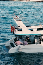 a white boat with people on it in the water