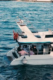a white boat with people on it in the water