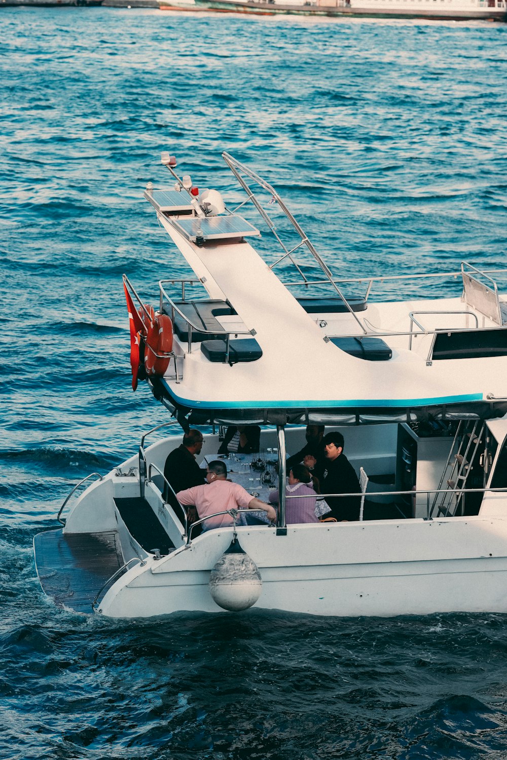 a white boat with people on it in the water