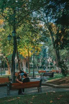 Neighbors chatting warmly at a local park bench.
