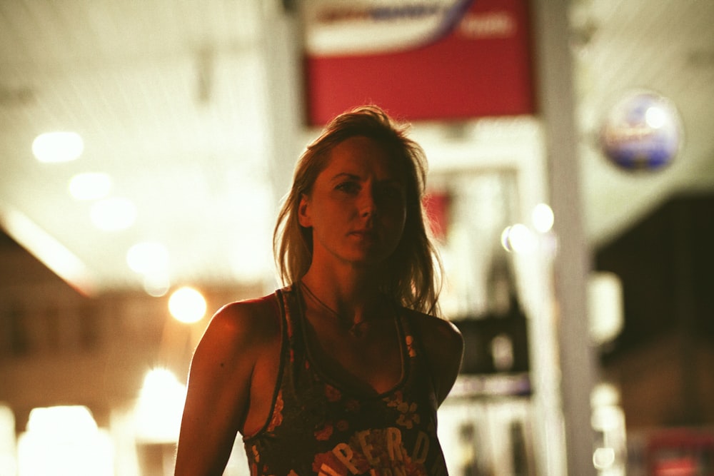 a woman standing on a street at night