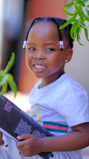 A joyful child reading a colorful personalized storybook with a big smile.