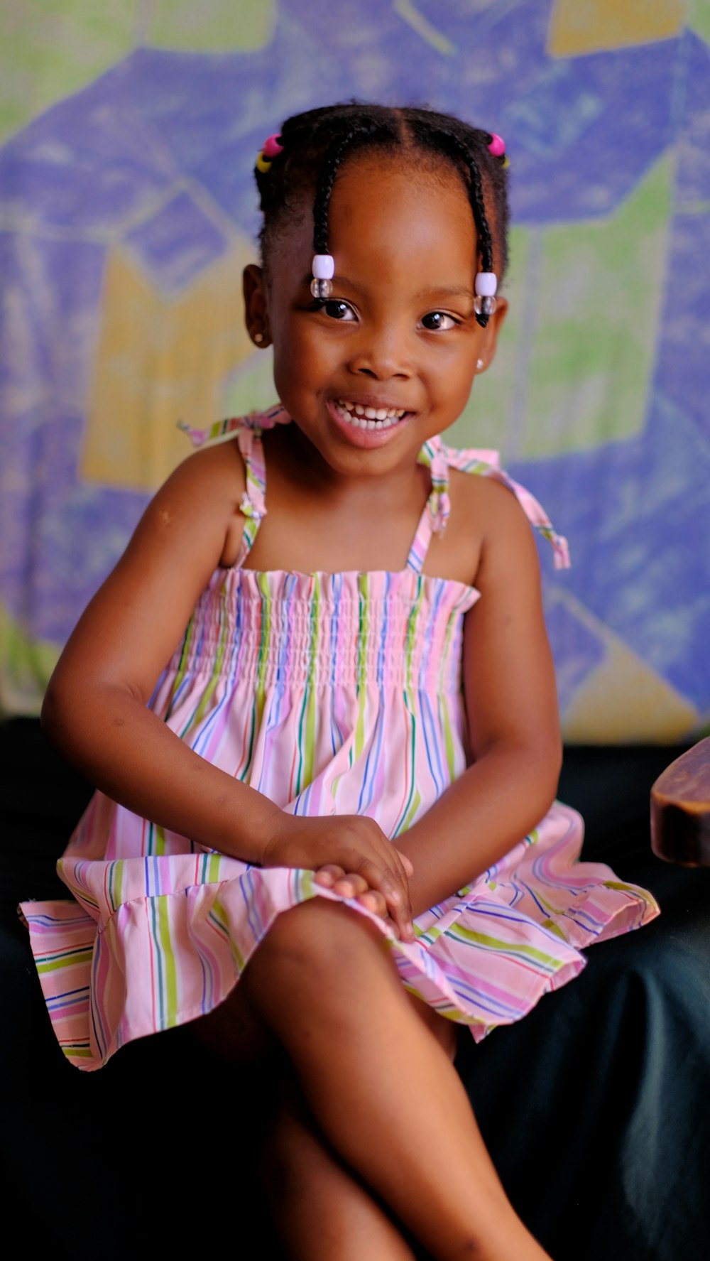 a little girl sitting on a couch smiling