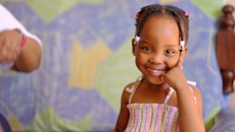 a little girl smiling at the camera with a smile on her face