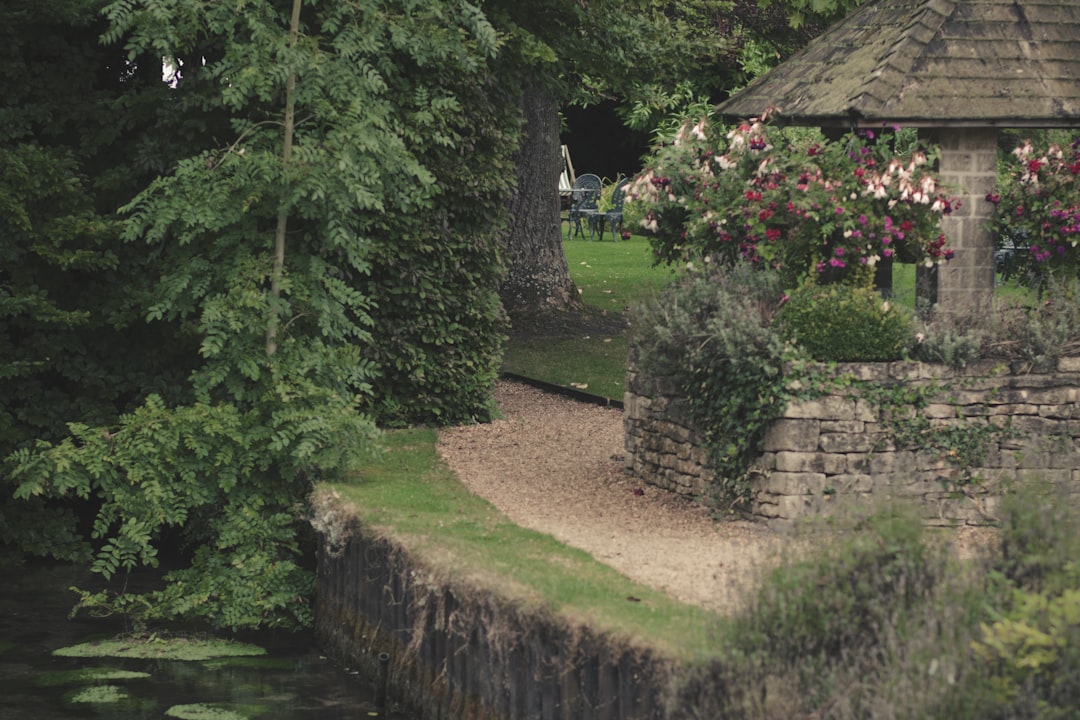 an umbrella is sitting on the edge of a stone wall,