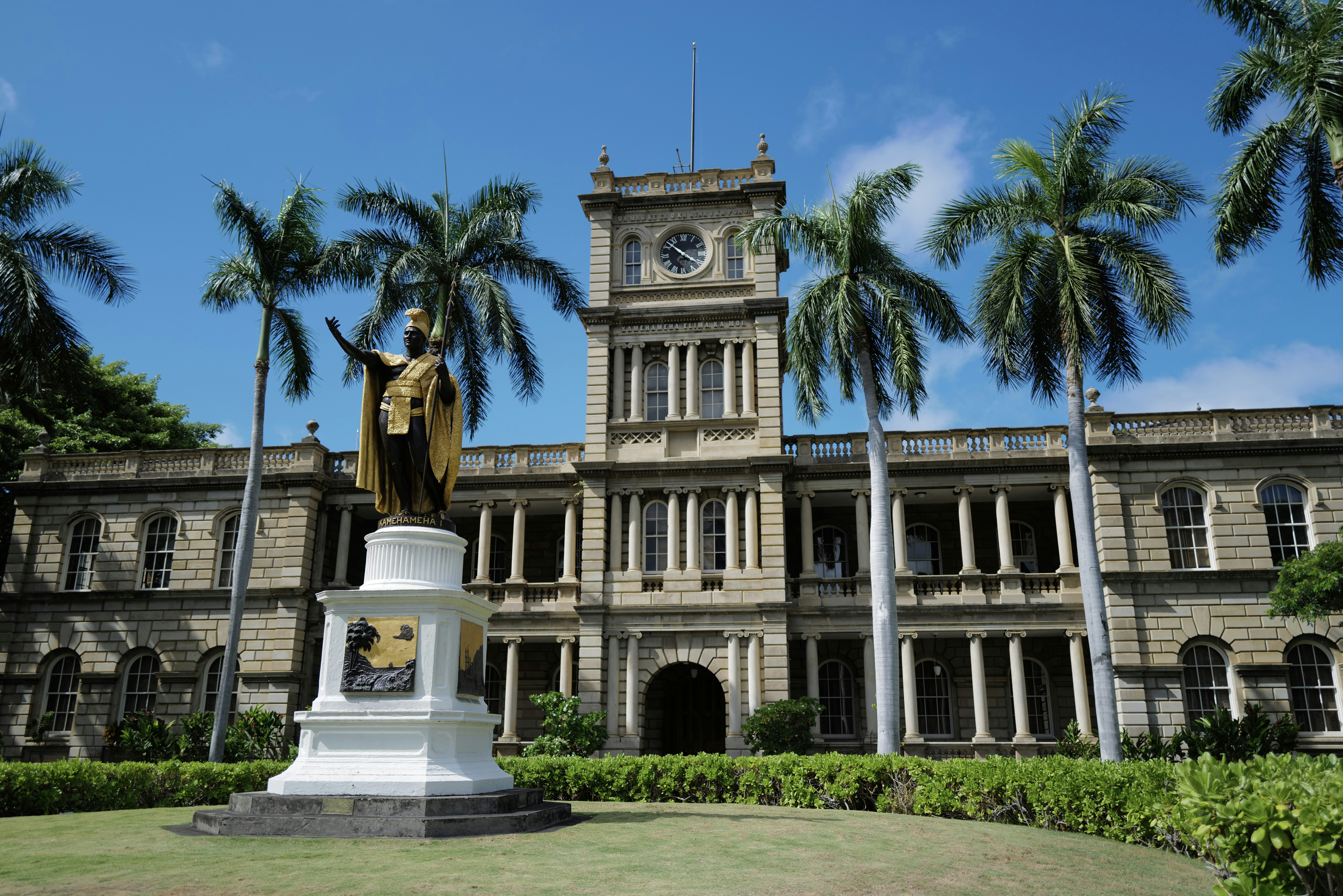 a statue in front of a large building with a clock tower