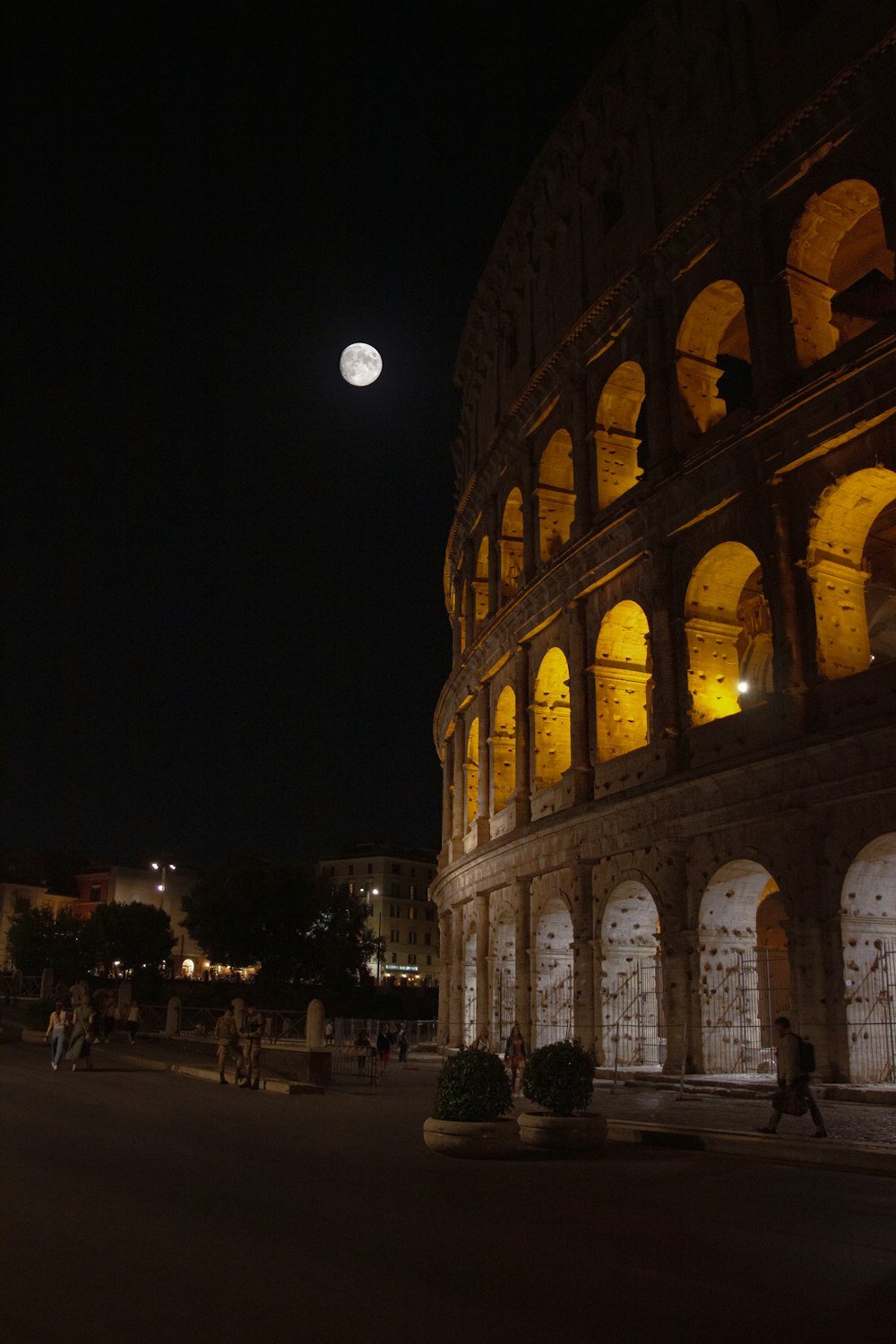 a full moon is seen above the colossion