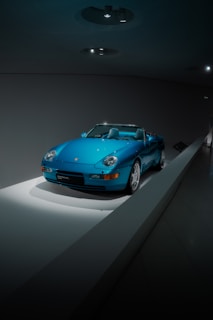 A sporty convertible highlighted under soft spotlighting in a contemporary showroom environment