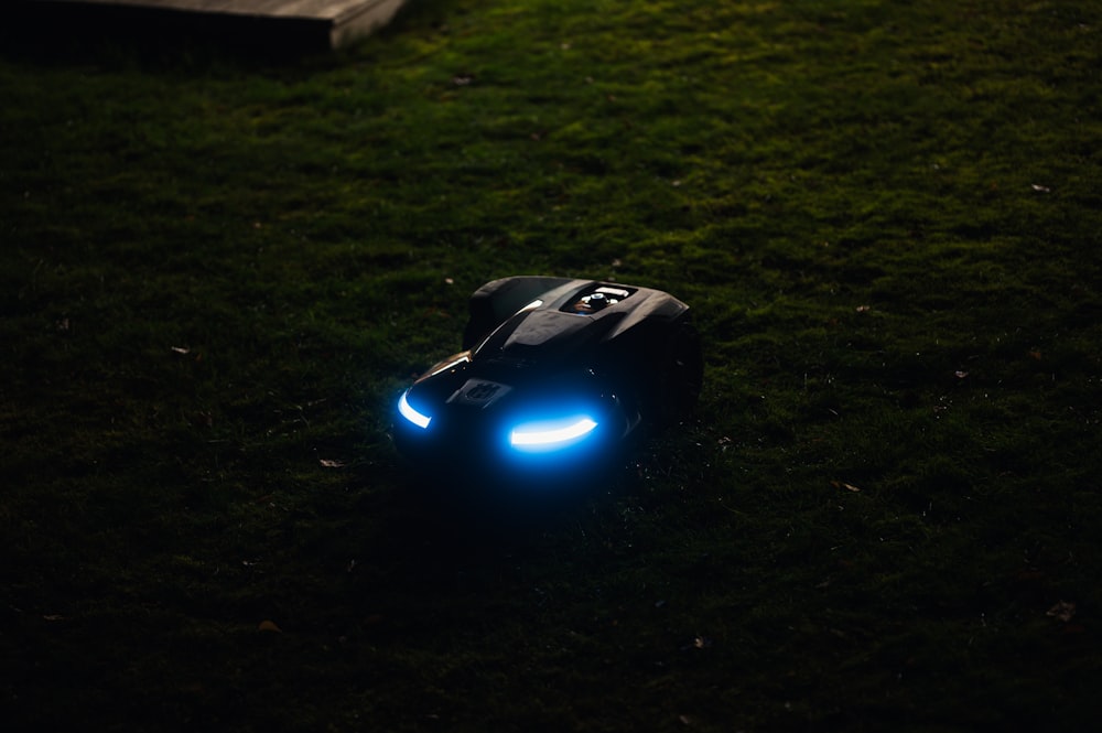 a toy car sitting on top of a lush green field