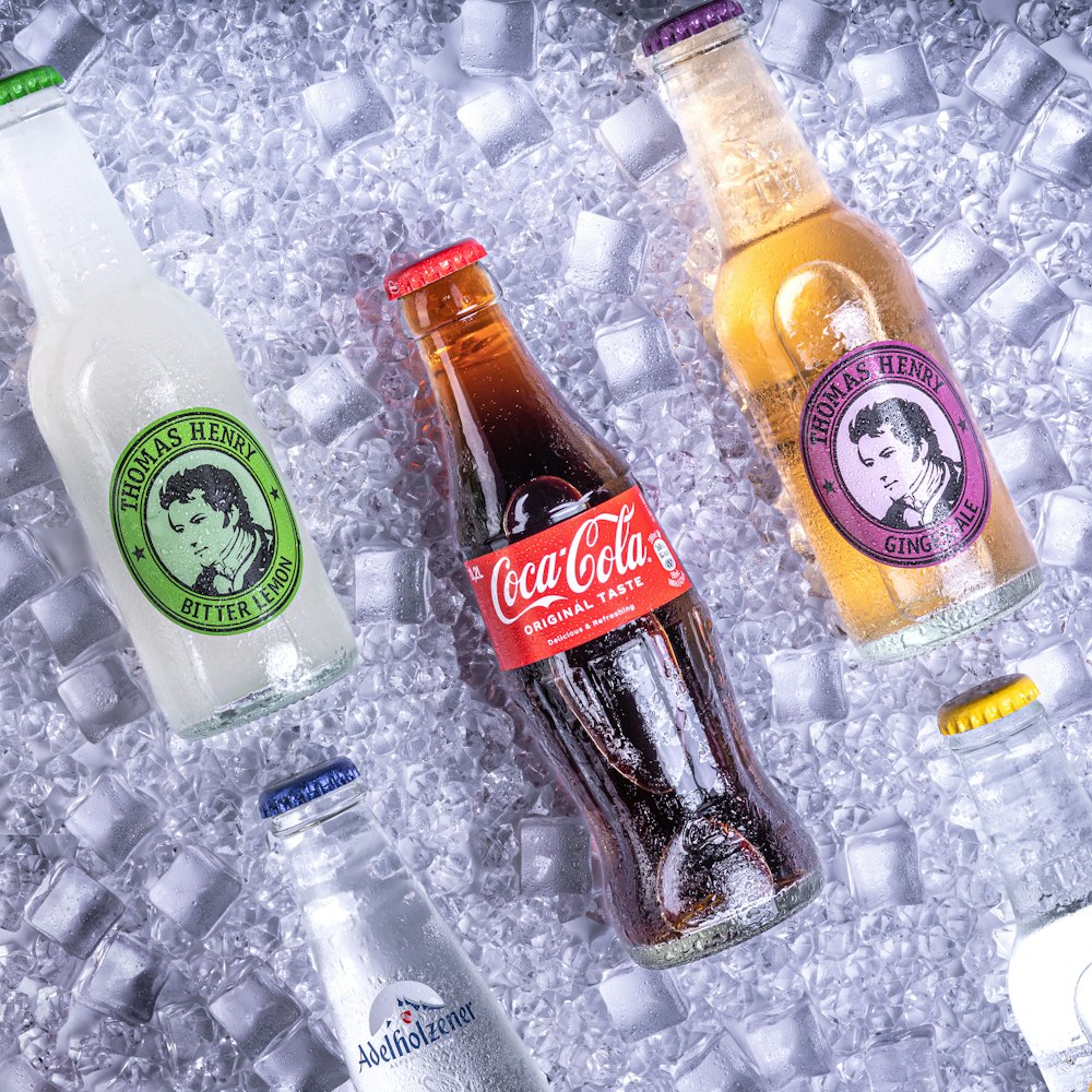 a group of bottles of soda sitting on top of ice