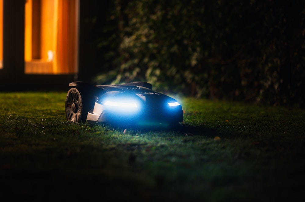 a toy car sitting in the grass at night