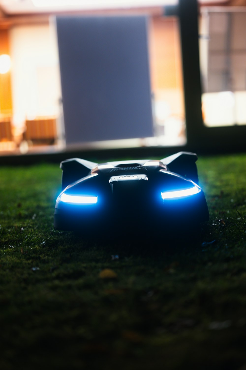 a toy car sitting on top of a lush green field