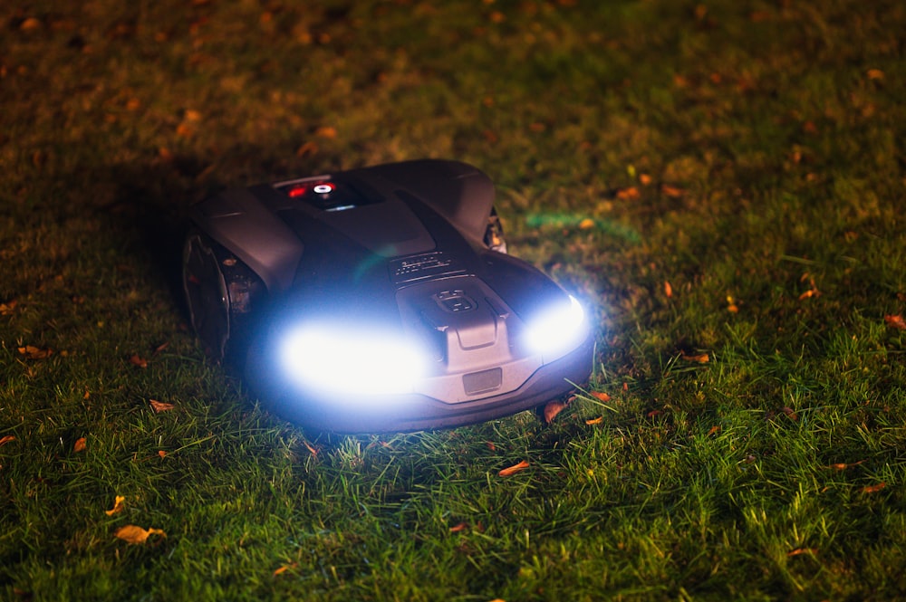a toy car with its headlights on in the grass