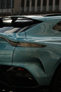 A sleek blue sedan gleaming after a full mobile detail under a bright sunny sky