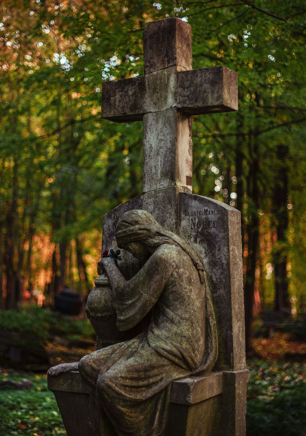 una estatua de una persona sentada sobre una tumba