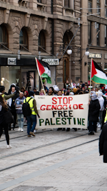 a group of people walking down a street holding flags