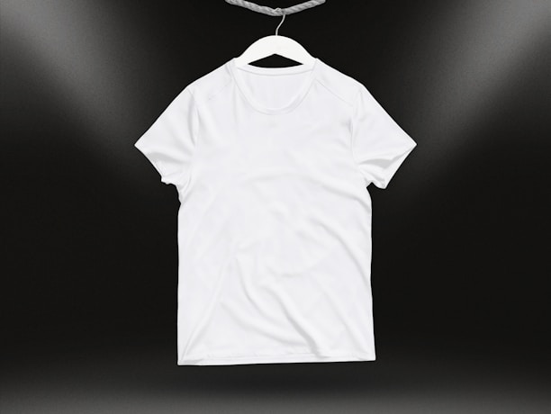 Close-up of a vibrant, soft cotton t-shirt draped over a wooden hanger against a clean white background.
