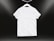 A plain white t-shirt on a hanger against a dark background. Soft lighting highlights the texture and folds of the fabric.