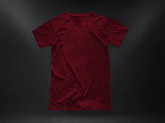 Close-up of a folded printed tee showcasing a detailed modern artwork in red and white tones.