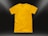 A plain yellow t-shirt is centered against a dark background, illuminated by subtle light gradients in the corners. The shirt is neatly laid out, highlighting its texture and smooth fabric.