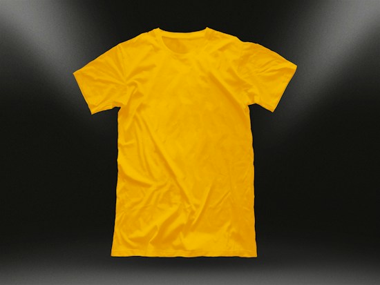 A plain yellow t-shirt is centered against a dark background, illuminated by subtle light gradients in the corners. The shirt is neatly laid out, highlighting its texture and smooth fabric.