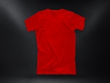 A plain red T-shirt is laid out against a dark background, with subtle lighting highlighting its texture and shape.
