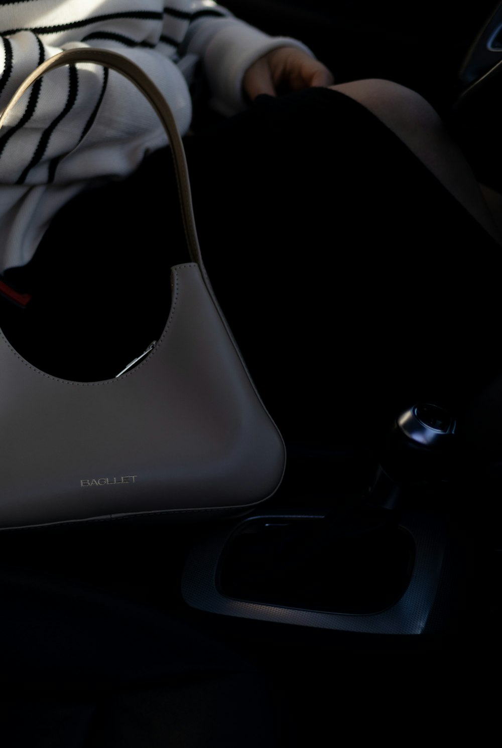 a white purse sitting on top of a car seat