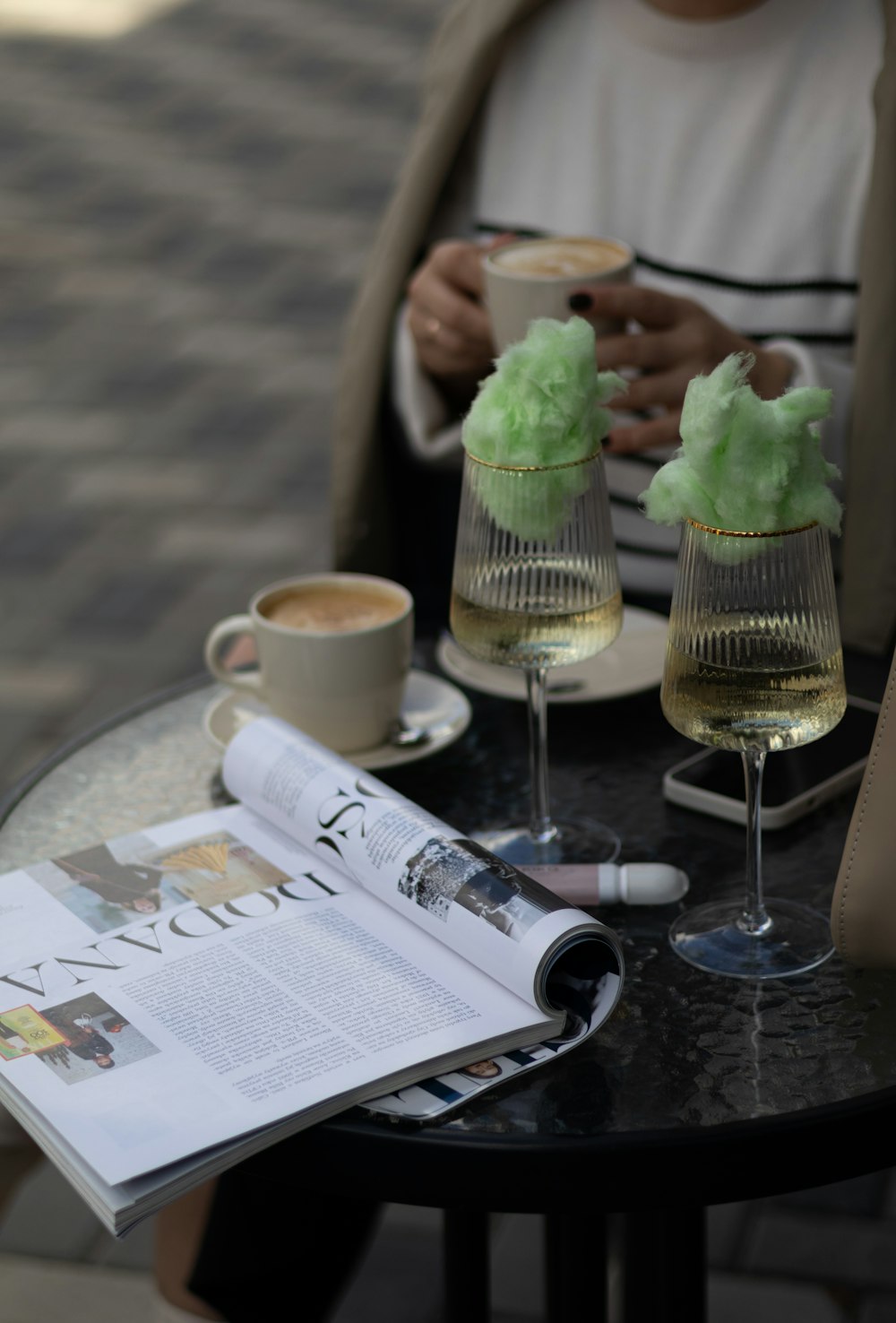 a person sitting at a table with two glasses of wine