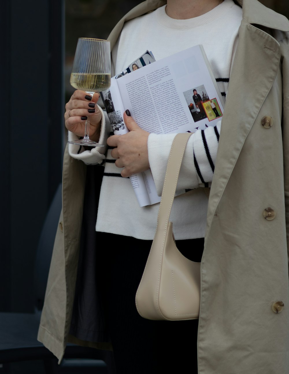 a woman holding a wine glass and a book