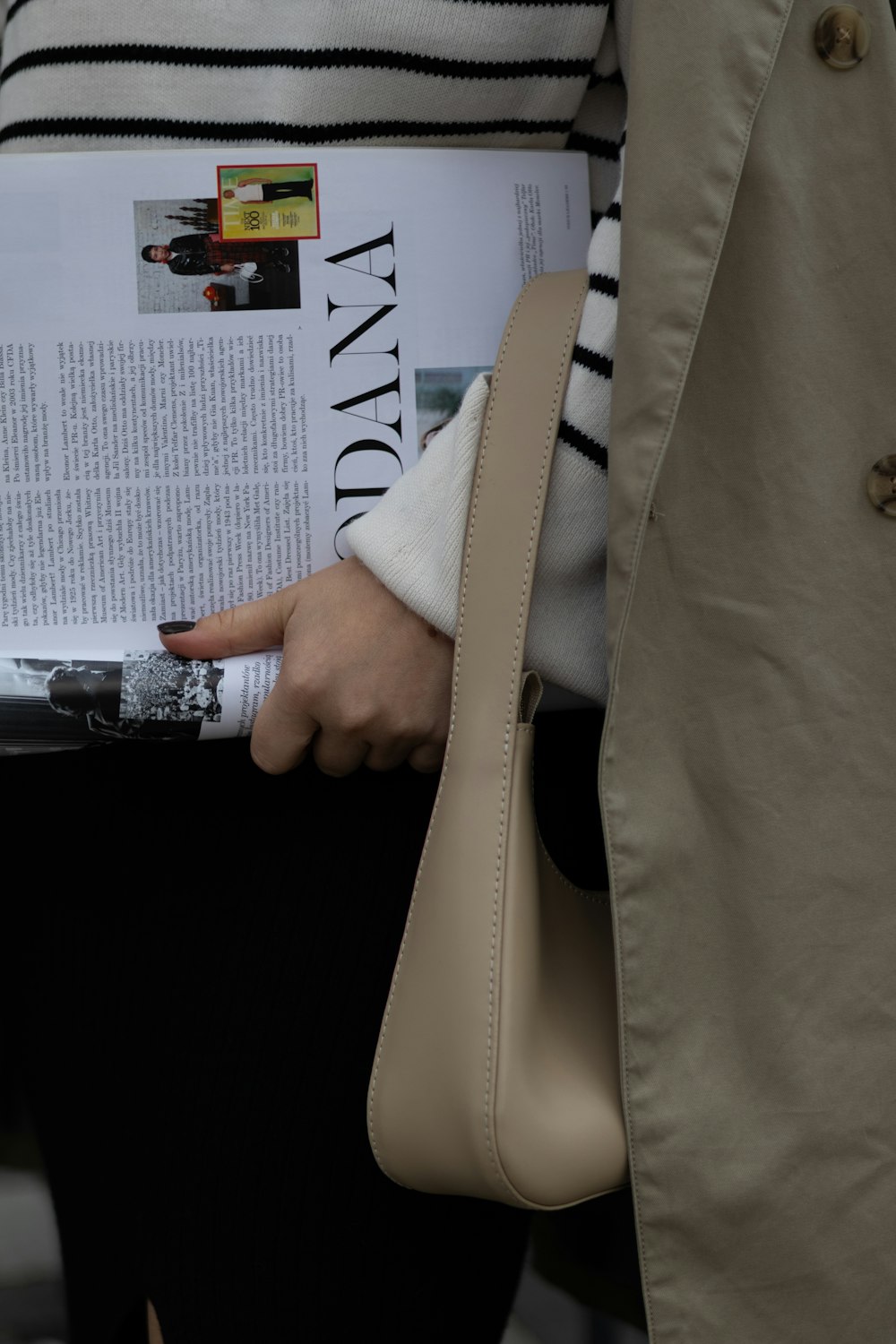 a woman is holding a magazine in her hand