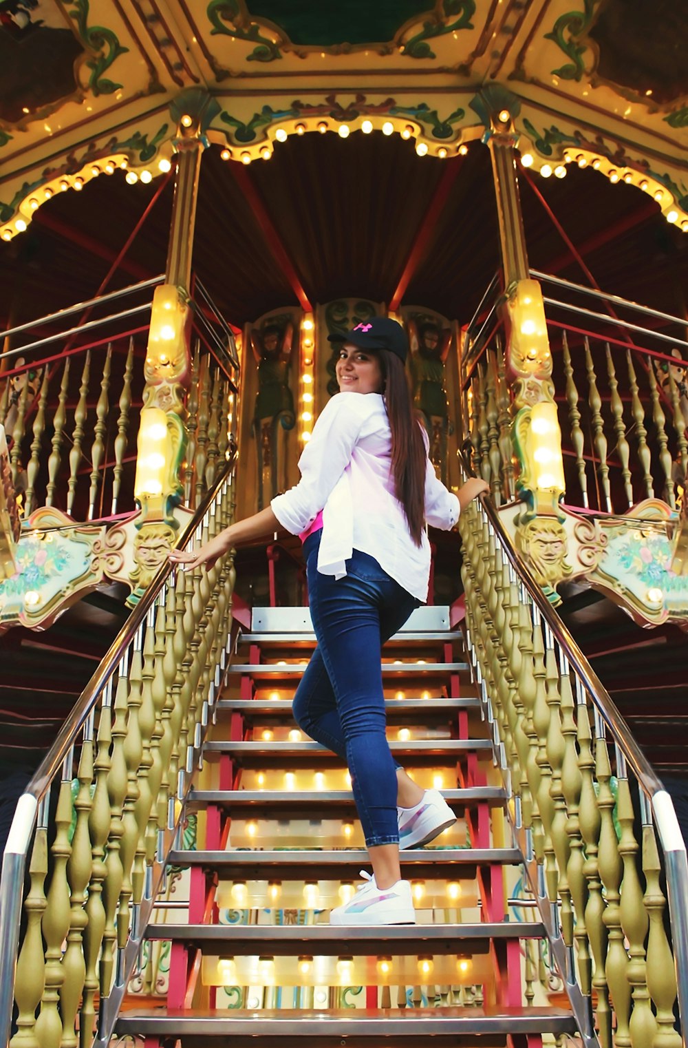 a woman standing on a set of stairs in front of a carousel
