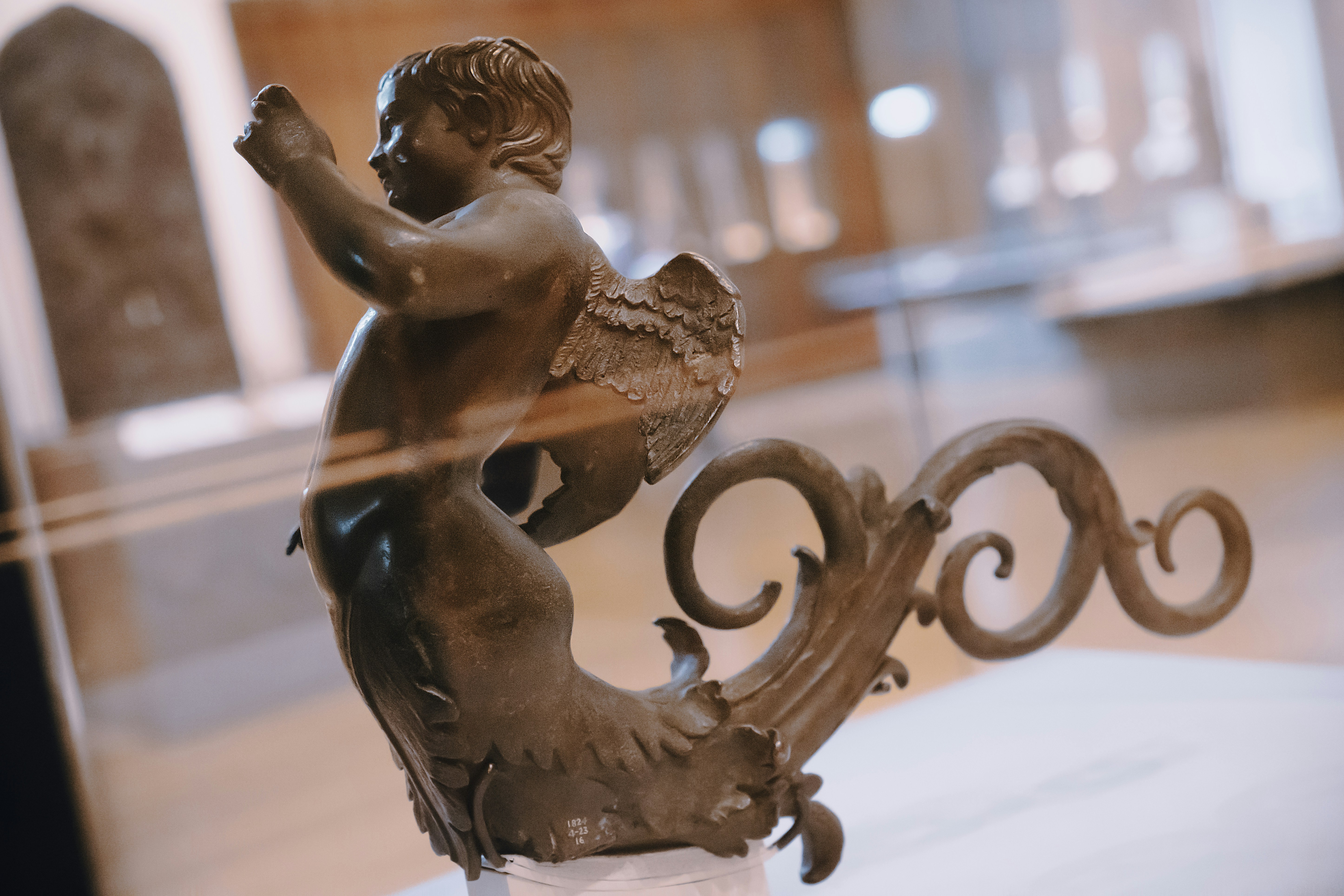 une statue d’une petite fille assise sur un banc