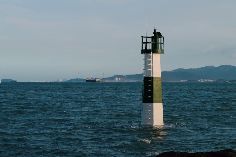 a light house sitting in the middle of a body of water