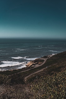 A scenic view of the Great Ocean Road with cliffs and ocean waves below.