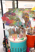 A vibrant summer gadget display featuring colorful mist fans arranged on a rustic wooden table.