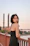 a woman in a black dress standing on a bridge