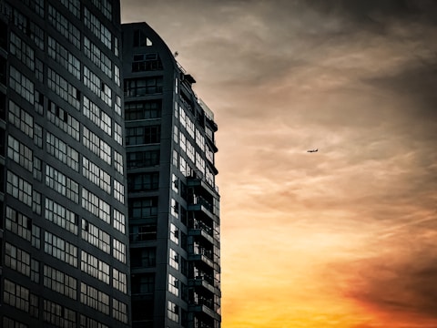 Wide shot of a high-rise building with dark aluminum cladding at sunset.